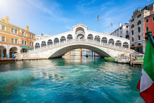 Beautiful view from the Canal Grande to the famous Rialto Bridge in Venice, Italy, without people and clear, emerald water