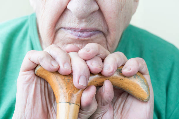木製の缶を持つ先輩の手を閉じる - human hand aging process senior adult cane ストックフォトと画像