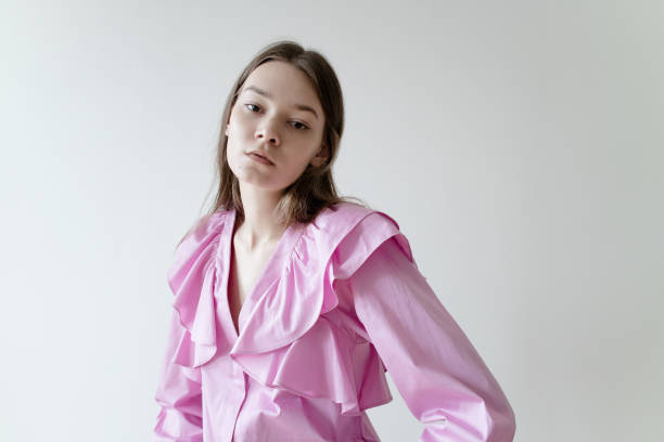 hermosa mujer joven con maquillaje de color nude usando blusa de camisa rosa sobre fondo blanco - puffed sleeve fotografías e imágenes de stock