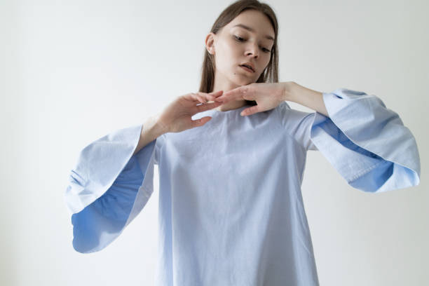 hermosa mujer joven con maquillaje de color nude usando vestido azul sobre fondo blanco - puffed sleeve fotografías e imágenes de stock