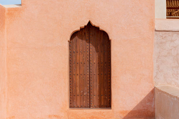 전통 아라비아 건축물, 이슬람 스타일의 나무 문과 붉은 점토 벽 - morocco islam pattern arabia 뉴스 사진 이미지