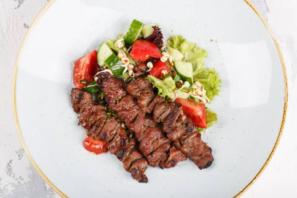 istock Beef skewers served on a plate with vegetable salad. 1224545835