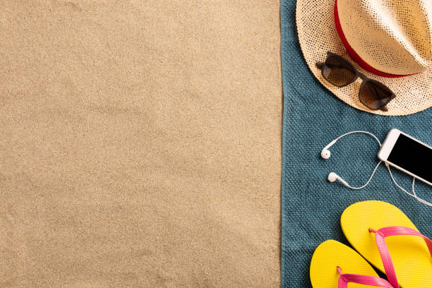 istock Straw has, sunglasses, smartphone and flip flops on the sand. Summer vacation concept 1224546843