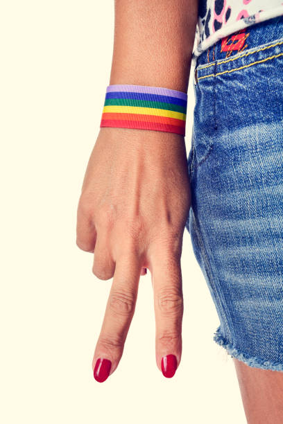 istock woman making the V sign, with a bracelet patterned as the rainbow flag 1224547014