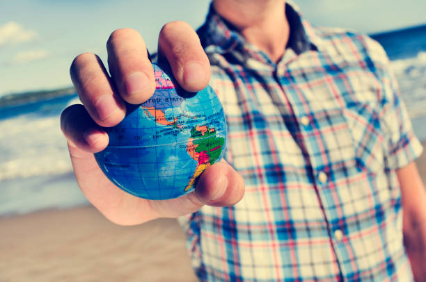 istock young man with a world globe in his hand 1224547029