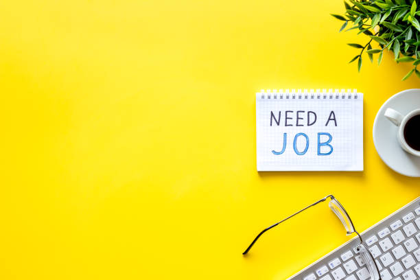 istock Need a job, looking for. Text on yellow office desk top-down space for text 1224547450