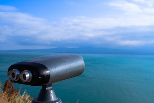 Tourist telescope with scenic view of the sea and blue sky.