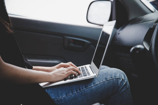 istock Closeup man hand with laptop sitting in his car 1224549729