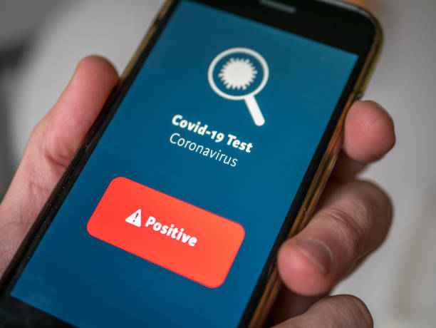 istock Smart phone app with corona virus test that show a positive result on device screen. 1224553602