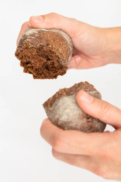 istock Hands dividing bun made of rye flour on two pieces 1224558003