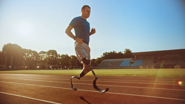 istock Athletic Disabled Fit Man with Prosthetic Running Blades is Training on an Outdoors Stadium on a Sunny Afternoon. Amputee Runner Jogging on a Stadium Track. Motivational Sports Shot. 1224561992