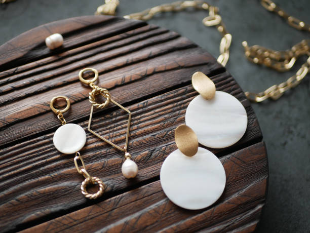 istock Gold earrings on a wooden background 1224564585