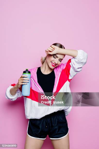 80s Style Portrait Of Smiling Woman In Sports Clothes Against Pink Background Stock Photo - Download Image Now
