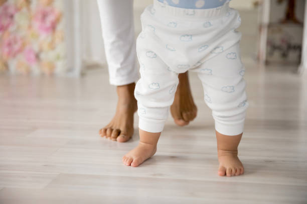 istock Close up of little baby make first steps with mom 1224568063