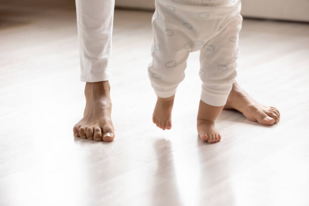 istock Close up of small toddler make first steps at home 1224568064