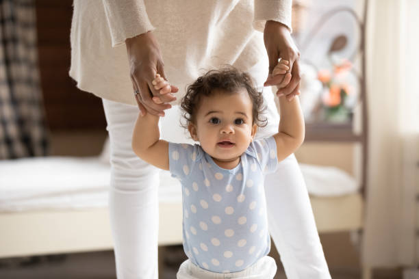 istock Cute little toddler learn walking holding mom hands 1224568069