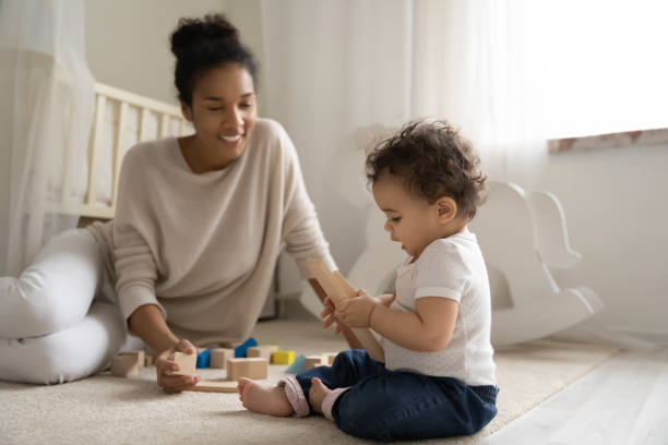 junge afrikanische amerikanische mutter spielen mit kleinem baby - cube baby child block stock-fotos und bilder