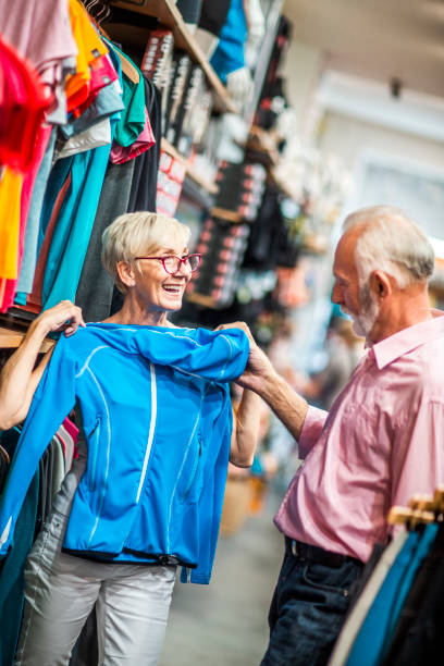 istock Senior woman shopping for an outdoors activities softshell jacket with her partner in a sports and outdoors store 1224568650