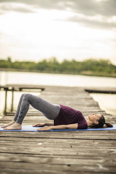 junge sportliche frau macht glute bridge übung - bridge exercise stock-fotos und bilder