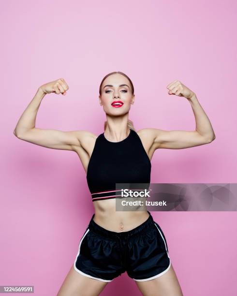 Portrait Of Slim Woman In Sports Clothing Against Pink Background Stock Photo - Download Image Now