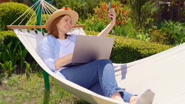 istock woman lies in hammock and working on computer 1224569743
