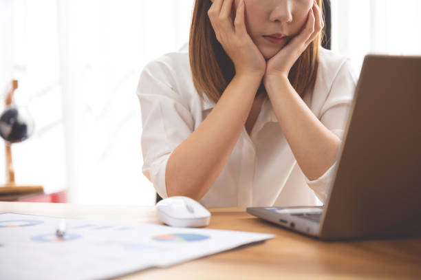 istock Stressed young Asian woman using laptop working at home 1224570291