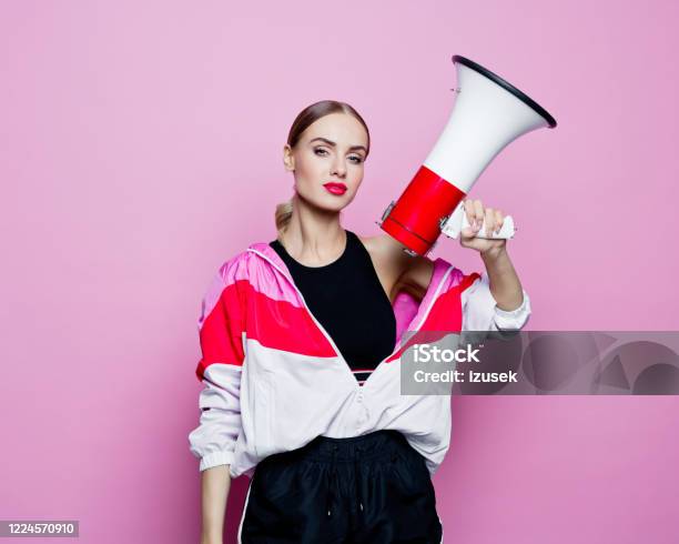 Sports Portrait Of Beautiful Woman In 80s Style Tracksuit Holding Megaphone Stock Photo - Download Image Now