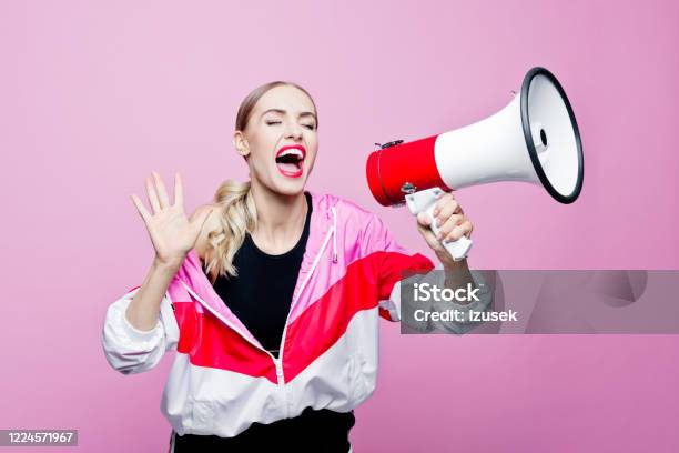 Sports Portrait Of Woman In Tracksuit Shouting Into Megaphone Stock Photo - Download Image Now