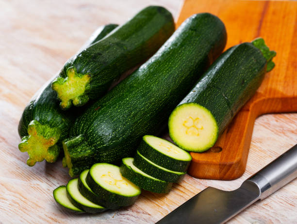 istock Whole and sliced fresh zucchini on wooden table 1224576282