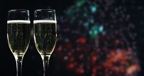 A champagne toast while in the background break out the fireworks. Concept: new year, love, holidays, party.