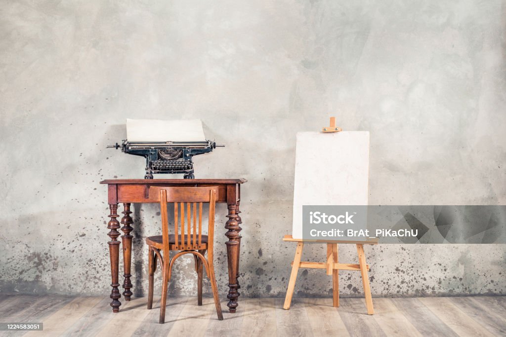 Vintage Typewriter With Sheet Of Paper On Old Oak Desk Easel Painting  Canvas Blank Aged Chair Front Grunge Concrete Wall Background Artists  Classic Workplace Concept Retro Style Filtered Photo Stock Photo 
