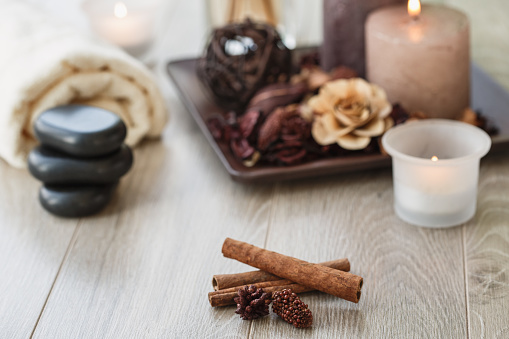 Selective focus of cinnamon sticks placed in front of a nicely displayed arrangment for a spa therapy to relax mind and body.