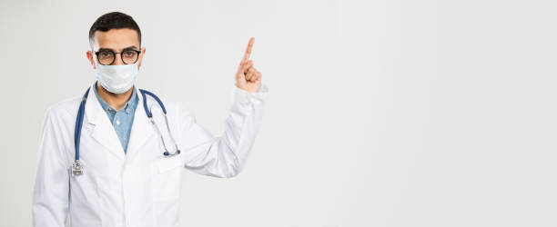 istock Coronavirus. Serious Arab female doctor showing on space for text. 1224584443