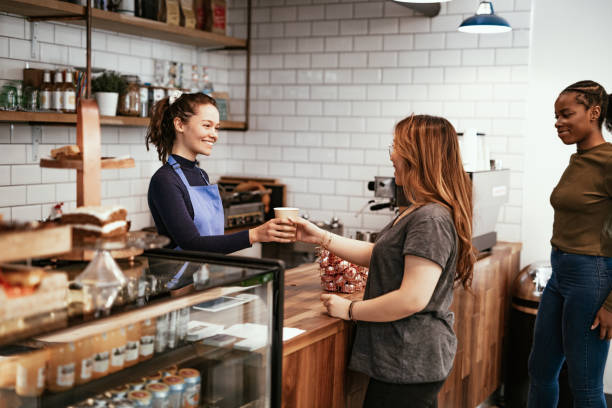 istock Barista in modern bar serving customers and smiling 1224587797