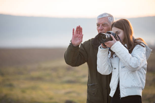 Grandfather Teaching Granddaughter How To Use a Camera