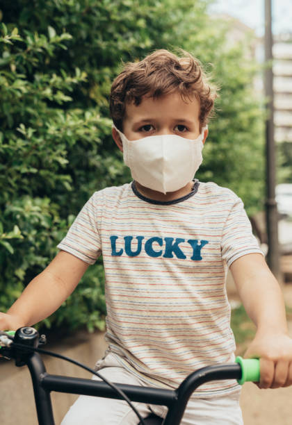 istock Boy riding bike with protective mask 1224593918