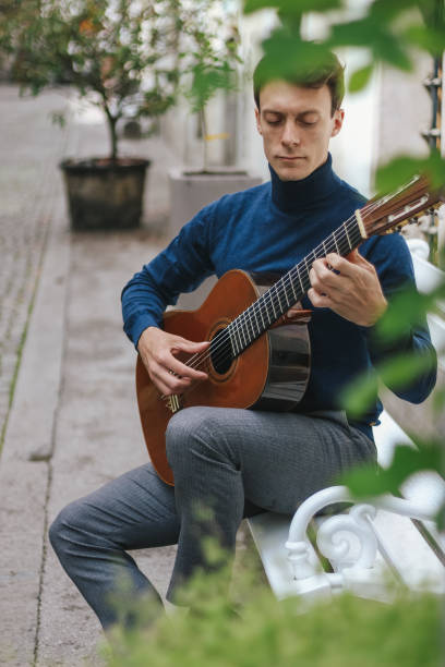 istock Young man playing a guitar outside 1224601981