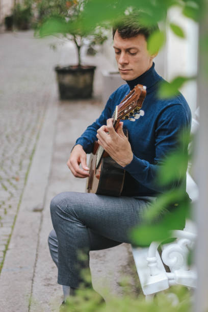 istock Young man playing a guitar outside 1224602138