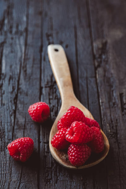 istock Fresh raspberries in wooden spoon 1224602716
