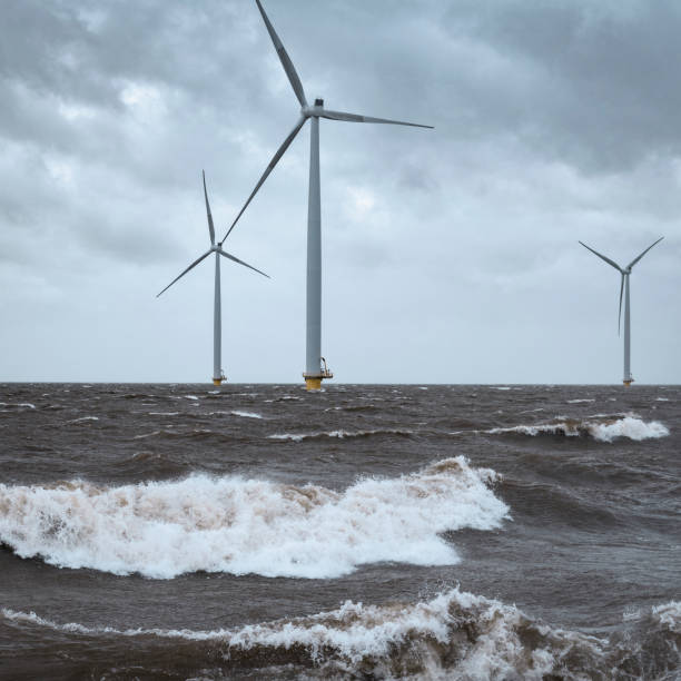 istock Wind turbines in an offshore wind park during a storm with big waves hitting the shore 1224602974