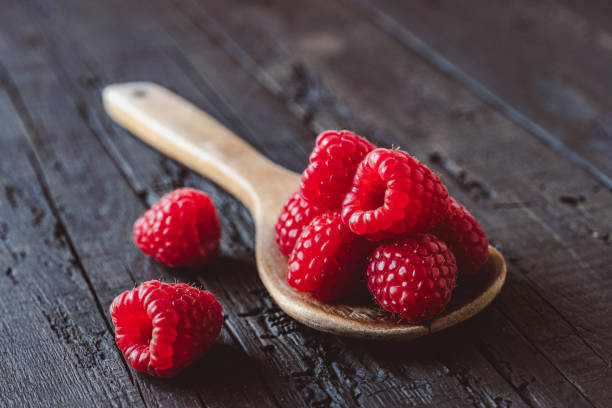 istock Fresh raspberries in wooden spoon 1224603097