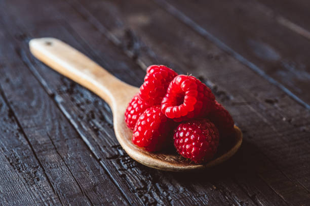 istock Fresh raspberries in wooden spoon 1224603196