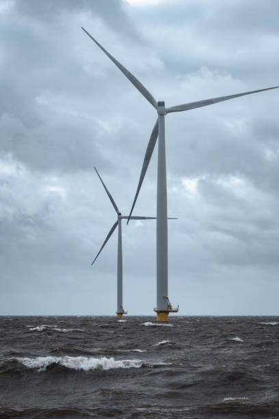 istock Wind turbines in an offshore wind park during a storm with big waves hitting the shore 1224603477