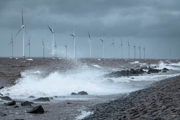 istock Wind turbines in an offshore wind park during a storm with big waves hitting the shore 1224603597