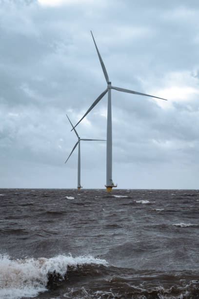 istock Wind turbines in an offshore wind park during a storm with big waves hitting the shore 1224604581