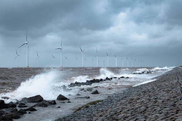 istock Wind turbines in an offshore wind park during a storm with big waves hitting the shore 1224604945