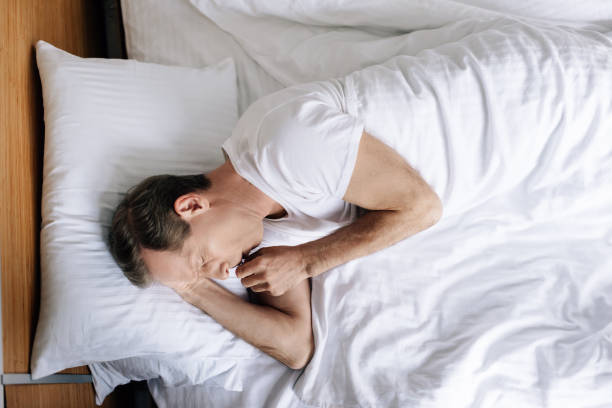 istock top view of sick man coughing while lying on bed 1224605574