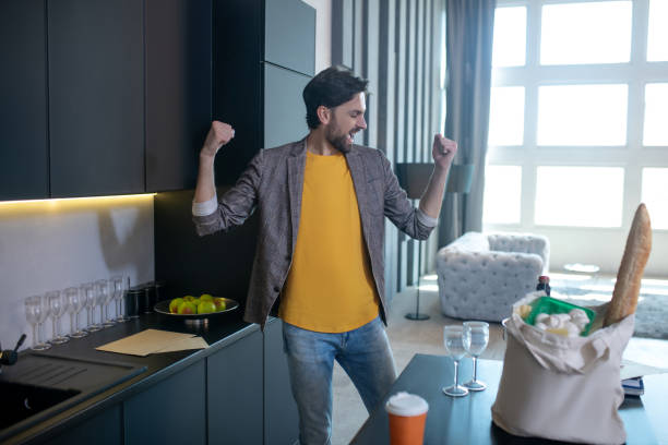 istock Young dark-haired man rejoicing at home in the kitchen. 1224608624