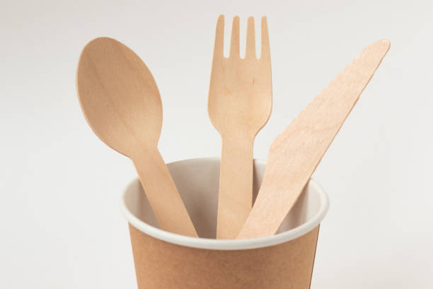 istock Eco friendly paper dishes. Craft cup, wooden cutlery: spoon, fork, knife. Recyclable tableware for fast food. Copy space. 1224610128