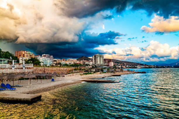 plage vide avec parasols de plage de roseaux, personne sur la plage. albanie, saranda. beau ciel de soirée, coucher du soleil. pas de voyageurs et de touristes. annulations dues au coronavirus covid-19. quarantaine. - beach cancelled close up color image photos et images de collection